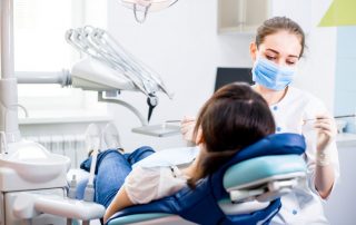 Dentist treats patient in dental chair