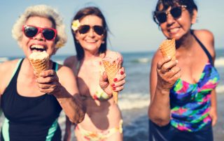 Senior women eating ice ream at the beach (Tips for Summer Dental Care)