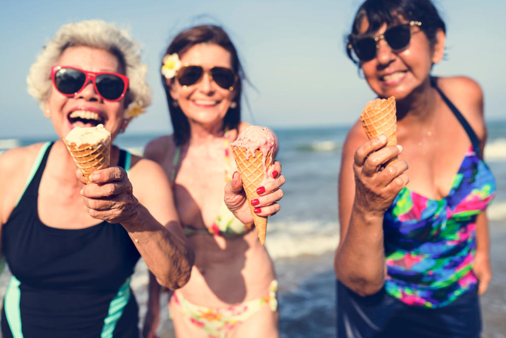 Senior women eating ice ream at the beach (Tips for Summer Dental Care)